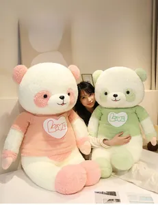 Large plush panda dolls wearing knitted sweaters with Love pattern in a cozy bedroom