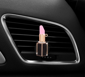 Detailed macro view of a pink lipstick car air vent aroma clip with sparkling rhinestones