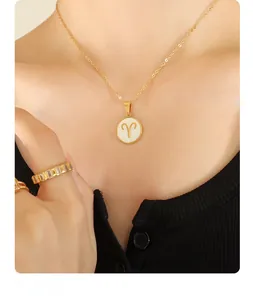 Detail view of a 12 zodiac Aries shell pendant necklace in gold-tone on a female model