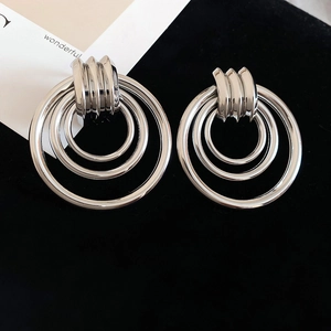 Makroaufnahme von hochglanzpolierten silbernen Etagen-Creolen mit konzentrischem Ringdesign