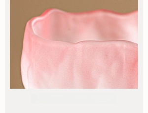 Macro shot of pink glacier tea cup with smooth wavy rim and thickened textured wall