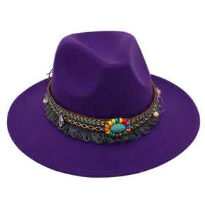 Dettaglio del cappello fedora in feltro viola con perline etniche, nappe e pietra turchese