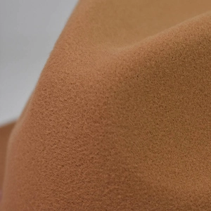 Vue rapprochée de la texture et du matériau épais en feutre de laine camel du bord du chapeau