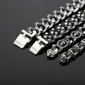 Detailed close-up of a double-row silver stainless steel skull bracelet with a secure clasp
