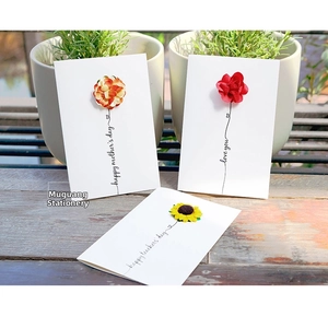 Macro detail of 3D floral greeting cards with handmade fabric flowers on wood