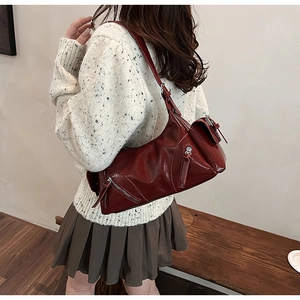 Detailed view of glossy wine red leather shoulder bag with metallic silver zipper