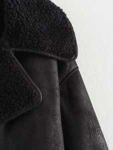 Détail macro de la doublure en peau de mouton et des coutures du col sur une veste noire