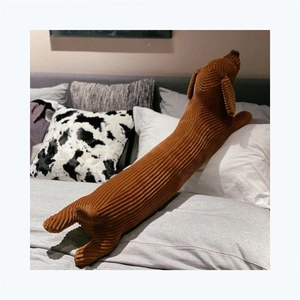Détail de la texture en velours côtelé d'un long coussin peluche teckel marron
