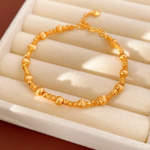 Detail of 24k gold plated beaded bracelet with matte and faceted beads in a jewelry box