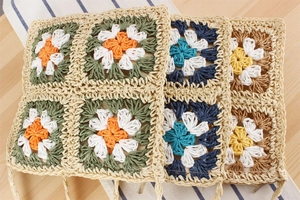 Détail macro de carrés au crochet faits main avec des motifs de marguerites colorées