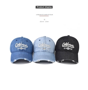 Close-up of three distressed denim baseball caps with California embroidery and ripped brims