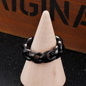 Detail view of black punk style titanium steel chain ring on wooden display stand