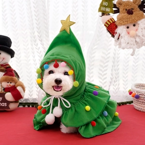 Detail of green Christmas tree pet cloak with gold star and colorful pom-poms on a dog
