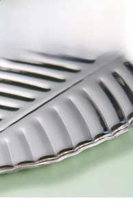 Detail of leaf-shaped golden stainless steel tray showing smooth edges and vein texture