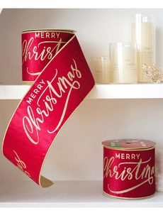 Detail of red velvet Christmas ribbon with golden Merry Christmas glitter printing
