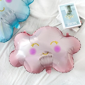 Detail of pink and blue rainbow smiley cloud balloons on white fabric for party decor