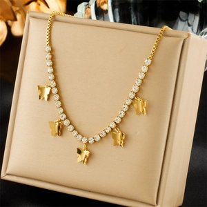 Detailed view of a gold butterfly pendant necklace with green crystals in a luxury jewelry box