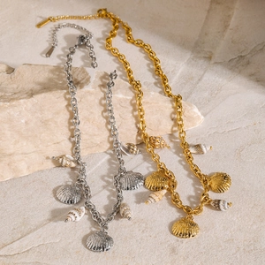 Detailed macro view of 18k gold and silver starfish shell necklaces on stone texture