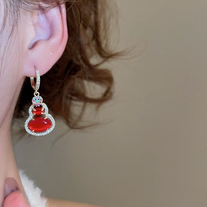 Macro shot of 14k gold plated gourd earrings with red resin and cubic zirconia stones