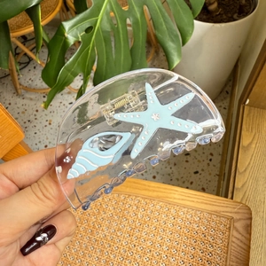 Handheld clear acetate hair claw clip with light blue starfish and seashell designs