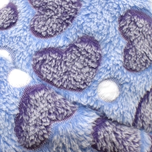 Gros plan sur tissu peluche bleu doux avec motifs de cœurs violets et pois blancs