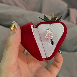 Pink heart gemstone ring in a cute red strawberry velvet jewelry box handheld view