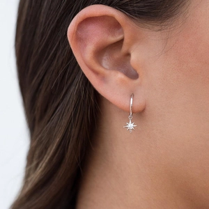Dettaglio dell'orecchino a stella in argento S925 con zircone scintillante su orecchio