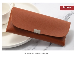 Detail of premium brown leather glasses case with metal closure on marble surface