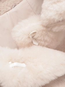 Close-up of premium faux fur collar in cream white with adjustable white buckle detail