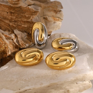 Modern geometric oval swirl earrings in gold and silver finish on natural stone background
