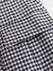 Gros plan sur le tissu en laine pied-de-poule noir et blanc et les coutures de poche