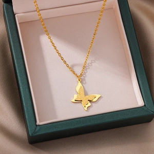 Detail of a 18k gold butterfly pendant necklace with matte and polished finishes on silk
