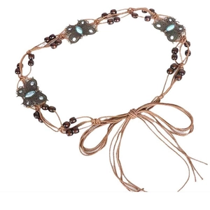 Detail of bohemian braided waist chain with butterfly metal charms and brown wooden beads