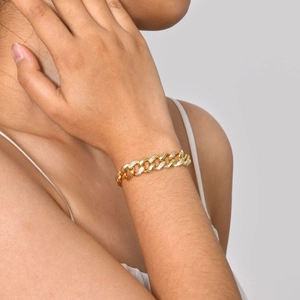 Detailansicht eines goldenen Gliederkettenarmbands mit funkelnden Zirkonias am Handgelenk