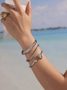 Détail de bracelets en zircone argentée et bague soleil lors de vacances à la plage