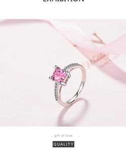 Close-up of pink princess cut zircon ring with side diamonds on a soft silk ribbon