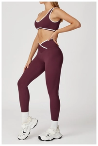 Detailaanzicht van de high-waist yoga legging met crossover taille en witte contrastbiezen