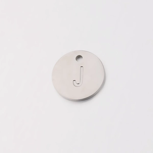 Close-up of a 12mm stainless steel circular pendant with a mirror finish and engraved letter J