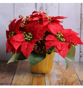 Close-up of red poinsettia Christmas centerpiece with gold berries and pine cones