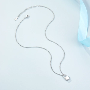 Macro shot of silver S925 padlock pendant necklace with adjustable chain on blue silk