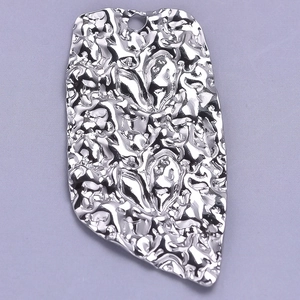 Macro shot of silver 304 stainless steel rectangle pendant with irregular lava texture