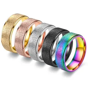 Detail of five matte titanium steel rings in gold, silver, rose gold, black, and rainbow
