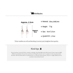 Detailed view of long shell tassel earrings with dimensions showing 9cm length and glass accents