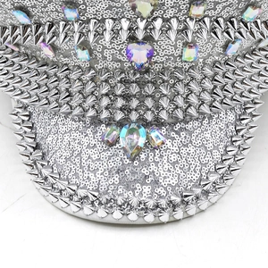 Détail de paillettes argentées, pointes métalliques et strass sur un chapeau de fête