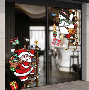Detail of Christmas stickers with Santa and snowman on ladder applied to a glass door