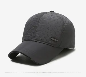 Detail of dark grey quilted baseball cap with warm lining and silver metal plate