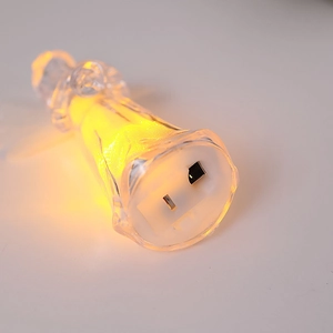 Macro detail of LED angel night light showing the US two-pin plug and warm glowing base