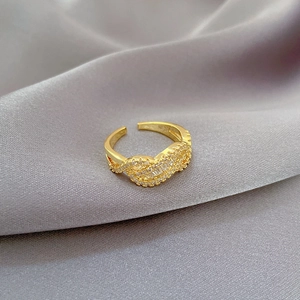 Adjustable gold twisted ring with micro-pave cubic zirconia on purple silk background