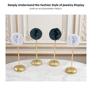 Detail of dark green and white resin ear-shaped jewelry stands with gold metal posts