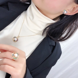Close-up of pearl jewelry set with enamel floral design on a model for display